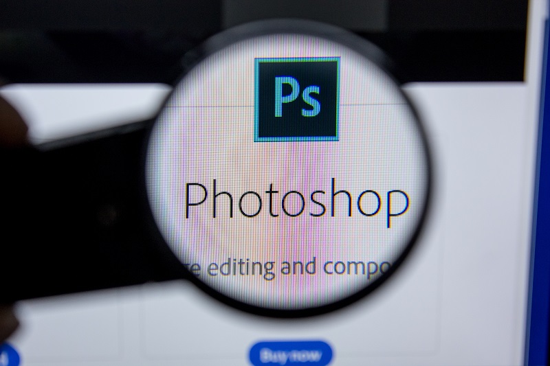 Kawałek ekranu z logo Photoshop powiększony za pomocą lupy